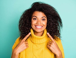 Girl wearing a yellow sweater and showing off brighter smile