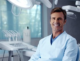 Male dentist smiling in an office chair 
