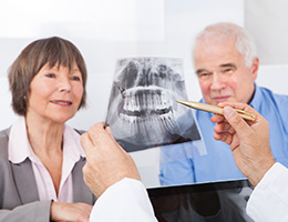 Senior man and woman looking at dental x-rays