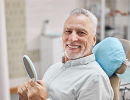 A happy elderly man sitting in a dentist’s chair