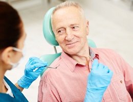A female dentist explains how dental implants work in Castle Rock to a male patient