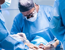 A dentist and their team performing a dental implant surgical procedure on a patient
