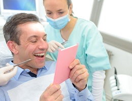 A male patient looks at his newly repaired smile in Castle Rock
