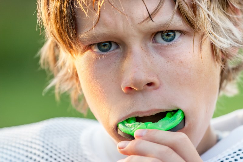 a young boy wearing a mouthguard while preparing for a game of football
