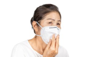 an elderly woman wearing a face mask to protect herself against COVID-19