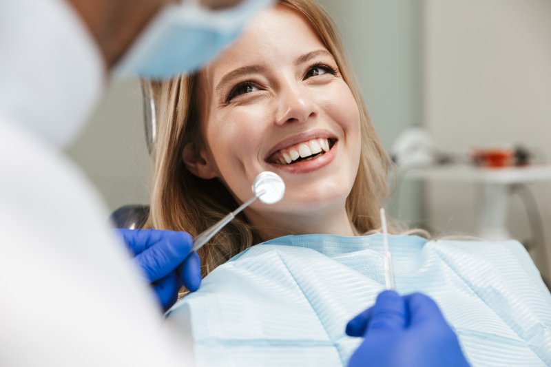 a young female smiling at her dentist during a dental checkup